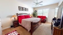 A cozy bedroom with red accents and wooden furniture.