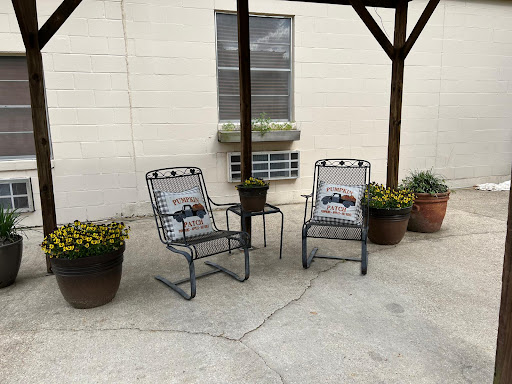 A peaceful outdoor seating area with comfortable chairs and potted plants.