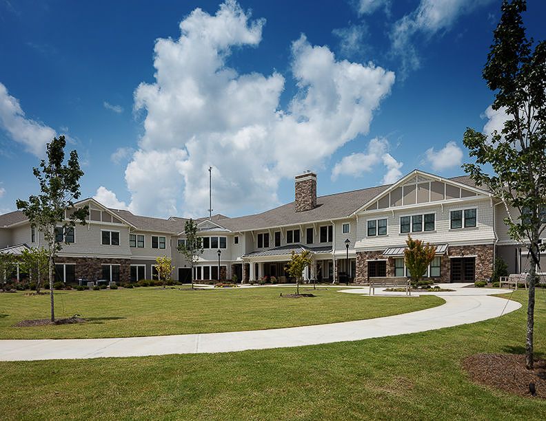 A spacious two-story residence with a well-maintained lawn under a cloudy sky.