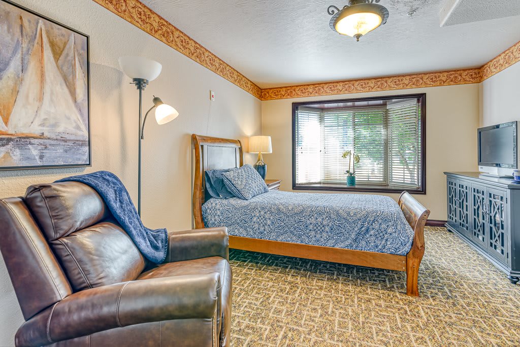A cozy bedroom with tasteful furnishings and large window.