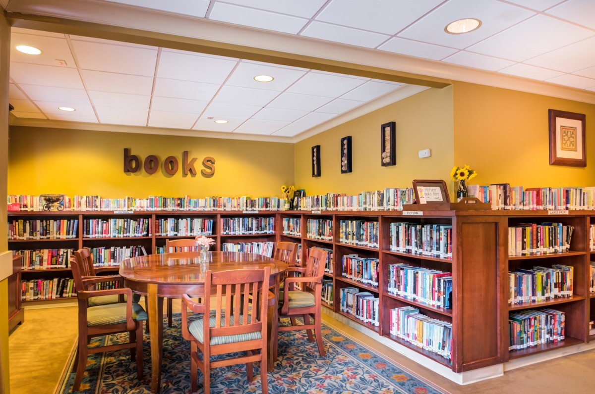 Cozy library corner with bookshelves and a reading table.