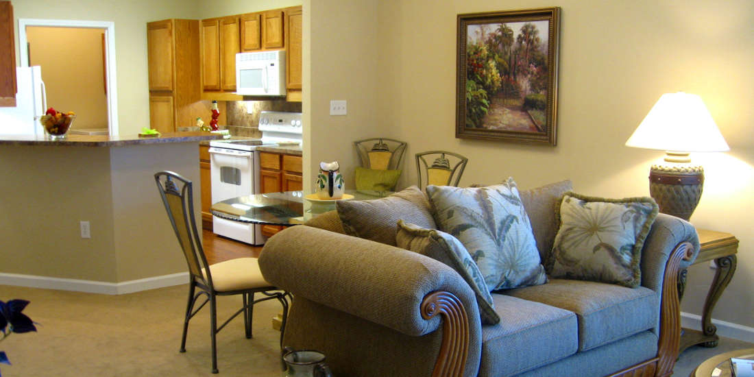 A cozy living area with an adjacent kitchen, featuring a comfortable couch and dining table.