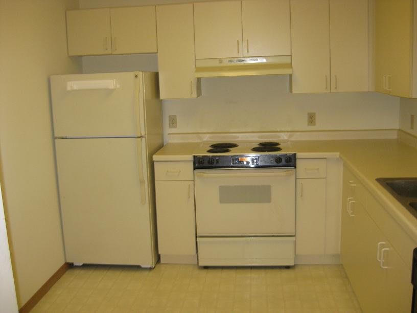 A simple kitchen setup with a fridge and stove.