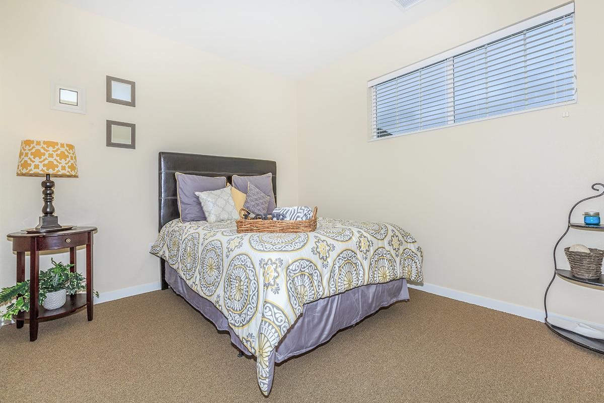 A cozy bedroom with a neatly made bed and simple decor.