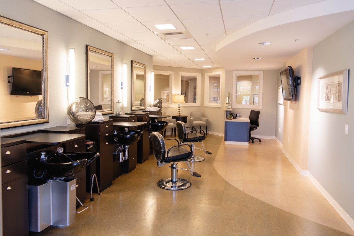 A modern hair salon interior with stylish chairs and mirrors.