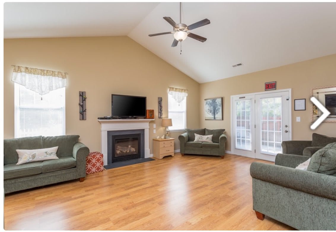 A spacious living room with a fireplace, television, and comfortable seating.