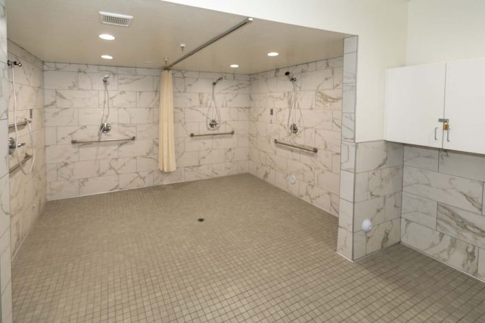 A modern tiled shower area with multiple showerheads and a clean design.