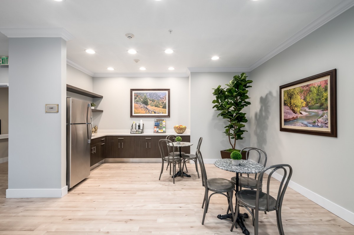 A modern kitchen and dining area featuring minimalistic design, stainless steel appliances, and elegant decor.