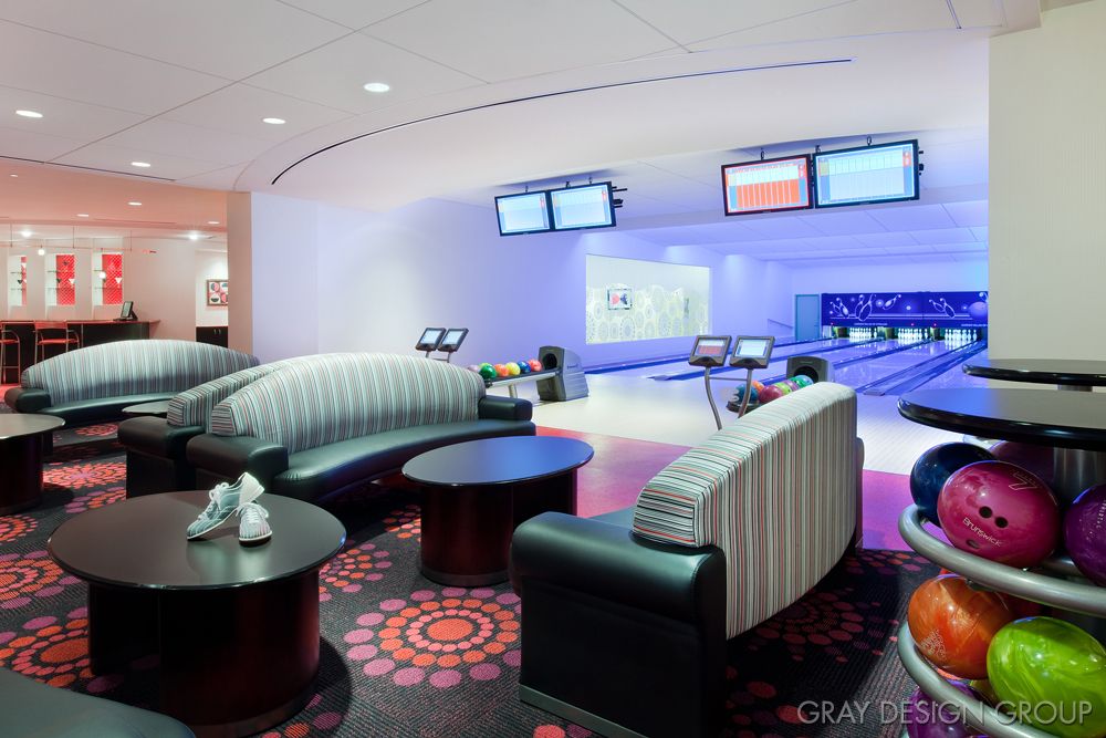 Modern bowling alley with comfortable seating and digital screens.