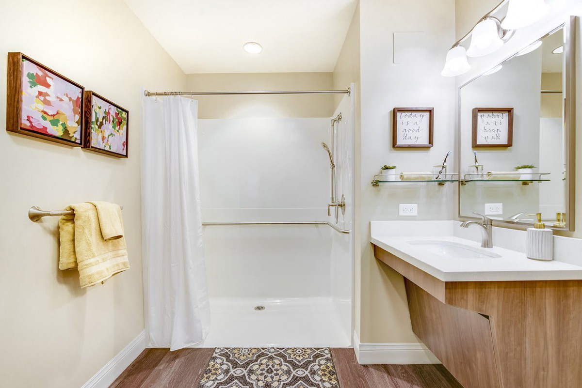 A clean and modern bathroom featuring a shower with a white curtain, a sink, and decorative elements.