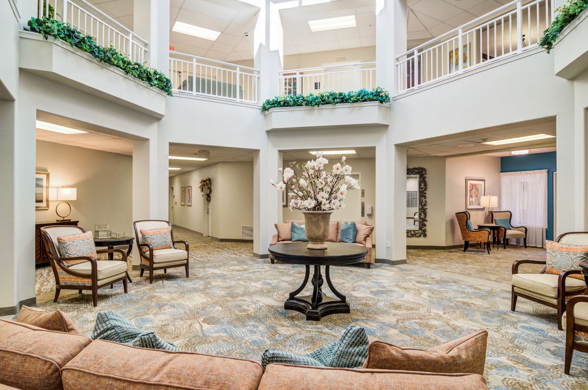A spacious and elegantly designed lobby area featuring comfortable seating, decorative plants, and natural lighting.