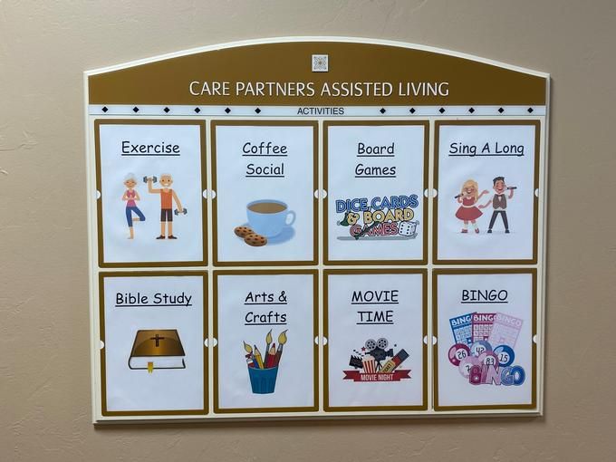 Activity schedule board at Care Partners Assisted Living featuring various activities such as exercise, cookie social, musical memories, sing-a-long, bible study, arts and crafts, movie time, and bingo.