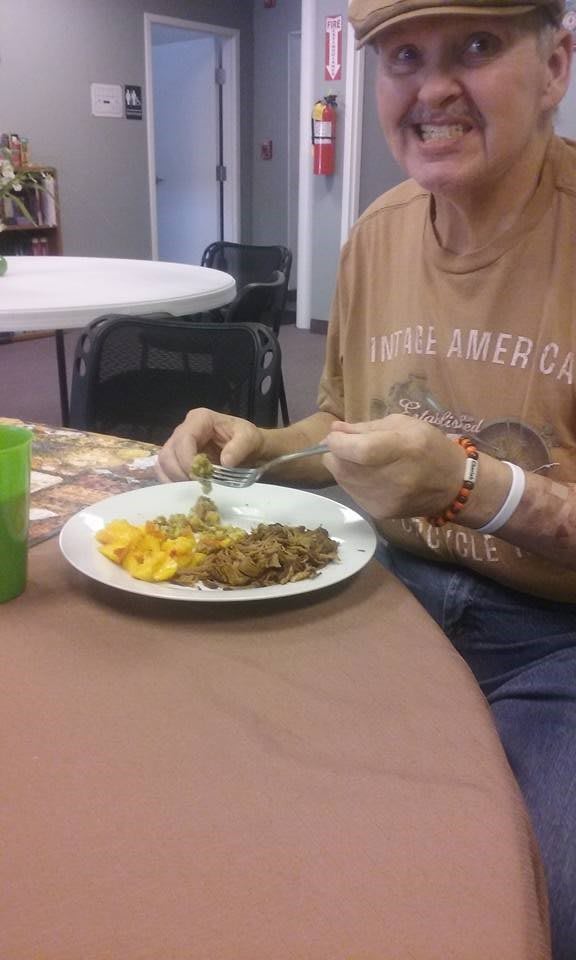 A person is eating a meal at a table with a plate of food.