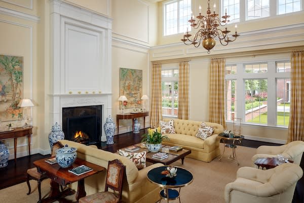 A spacious living room featuring elegant decor with a chandelier, fireplace, and comfortable seating.