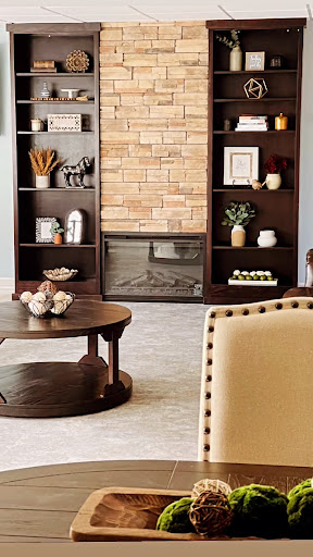 A cozy living room featuring a stylish bookshelf, a warm fireplace, and a modern coffee table.