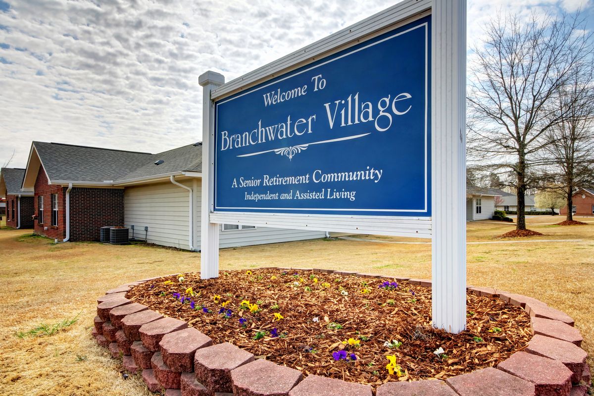 A sign for Breakwater Village, a senior retirement community, with landscaped surroundings.