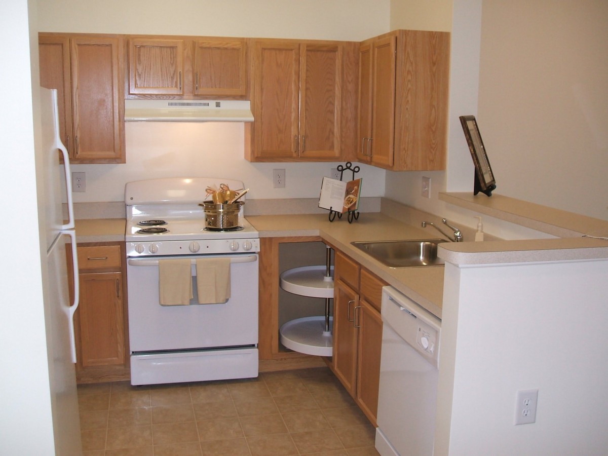 A kitchen with wooden cabinets, a stove, and various appliances.