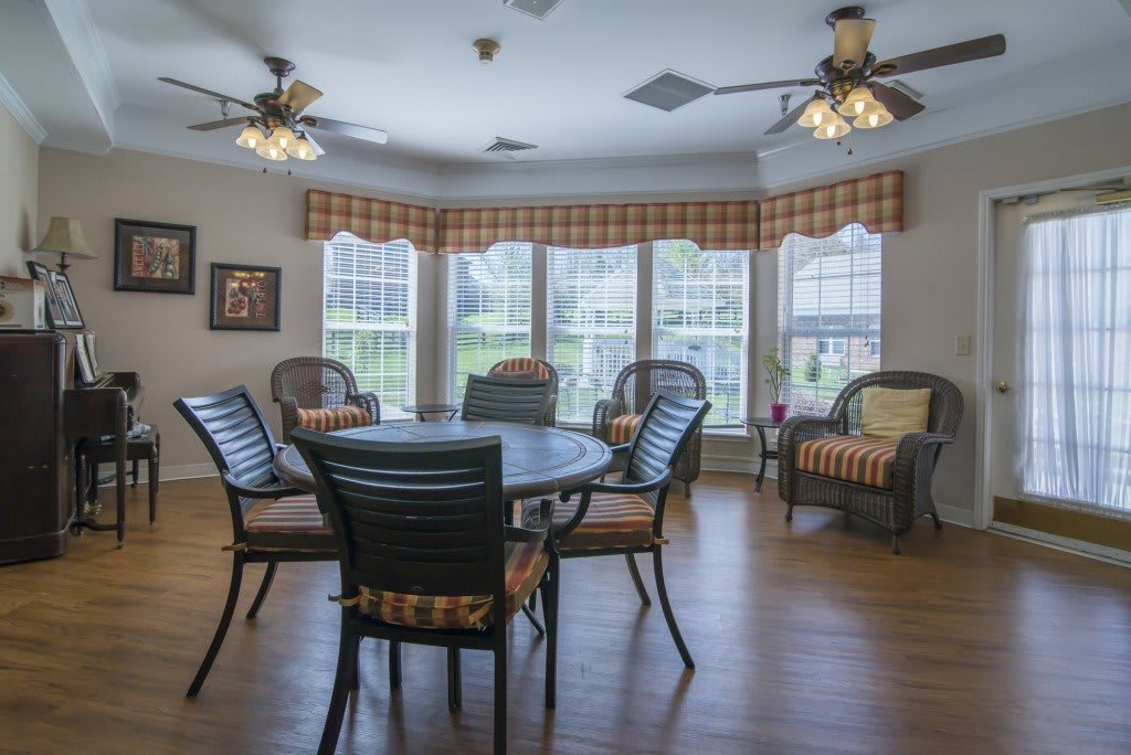 A cozy living room with multiple seating arrangements, large windows, and abundant natural light.