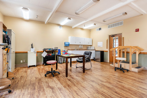 A spacious office workspace featuring a desk, chairs, and ample lighting.