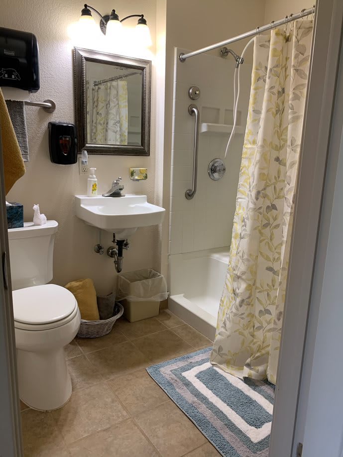 A neatly organized bathroom with a shower, toilet, and sink.