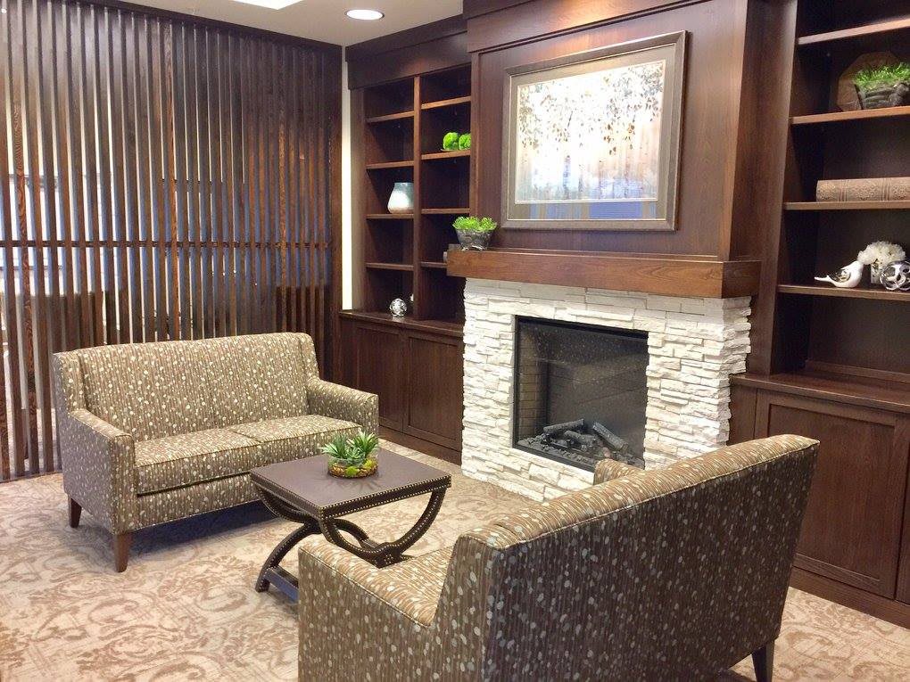 A cozy living room with a modern fireplace, sofas, and stylish decor.