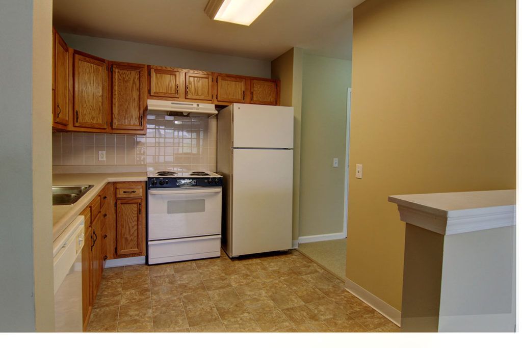 A cozy kitchen with wooden cabinets and essential appliances.