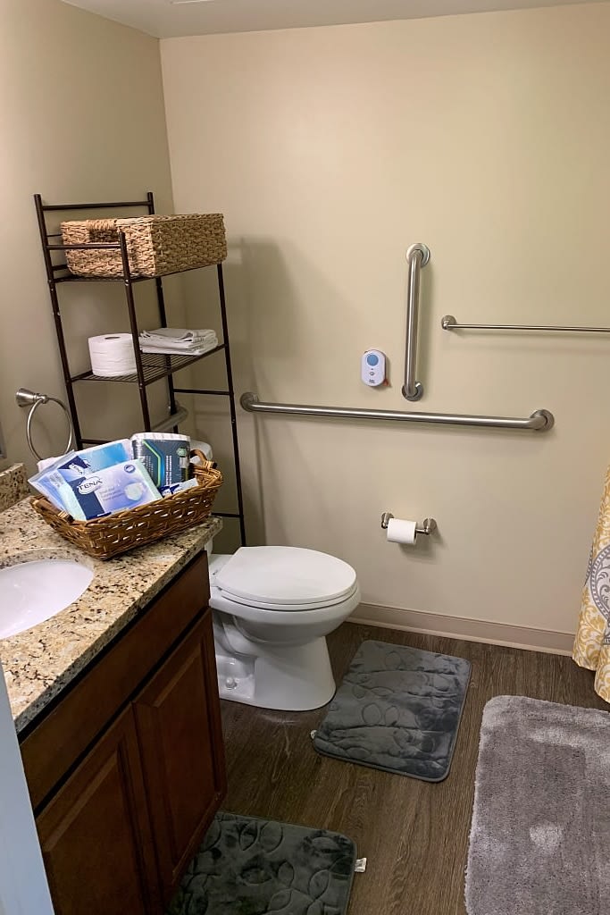 A clean and organized bathroom with safety features and storage.