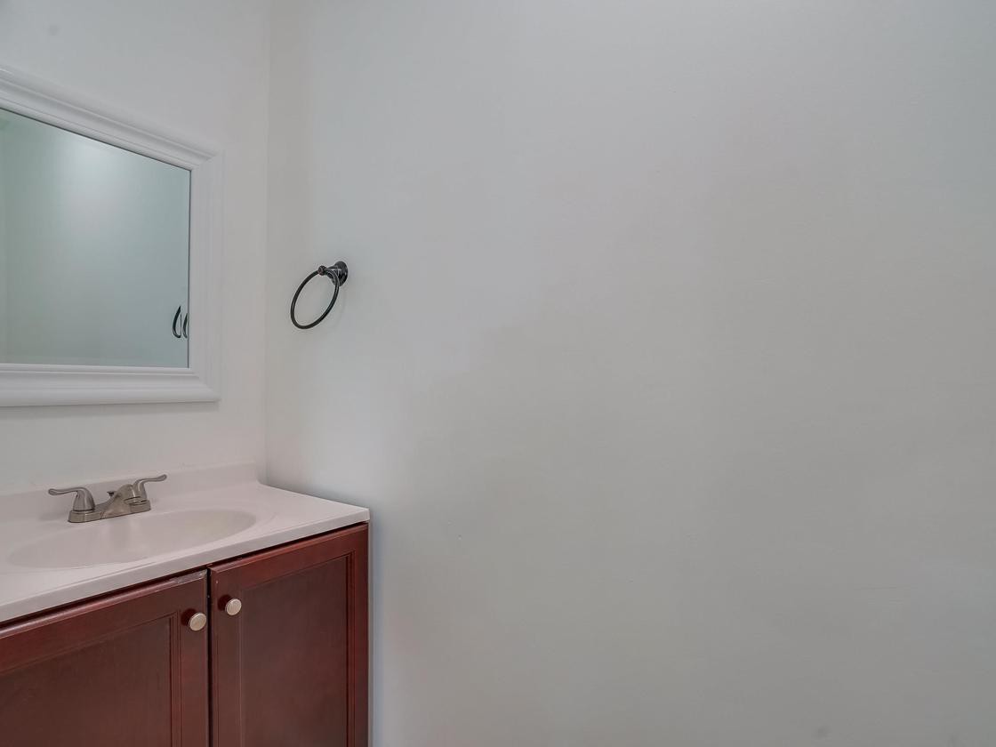 A minimalist bathroom with a vanity sink and mirror.