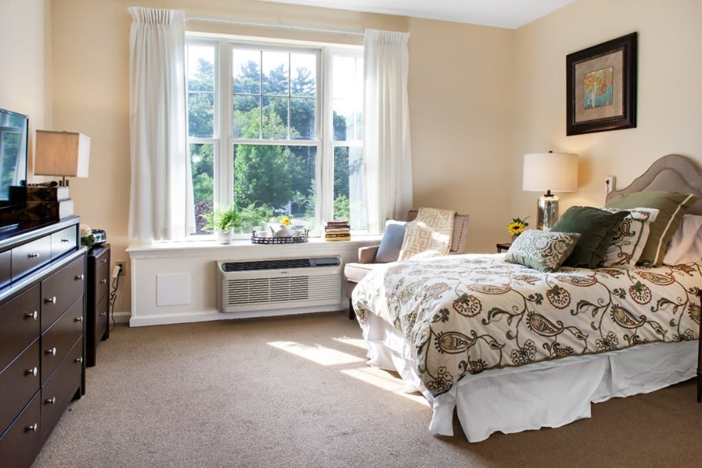 Bright and cozy bedroom with a large window and comfortable furnishings.