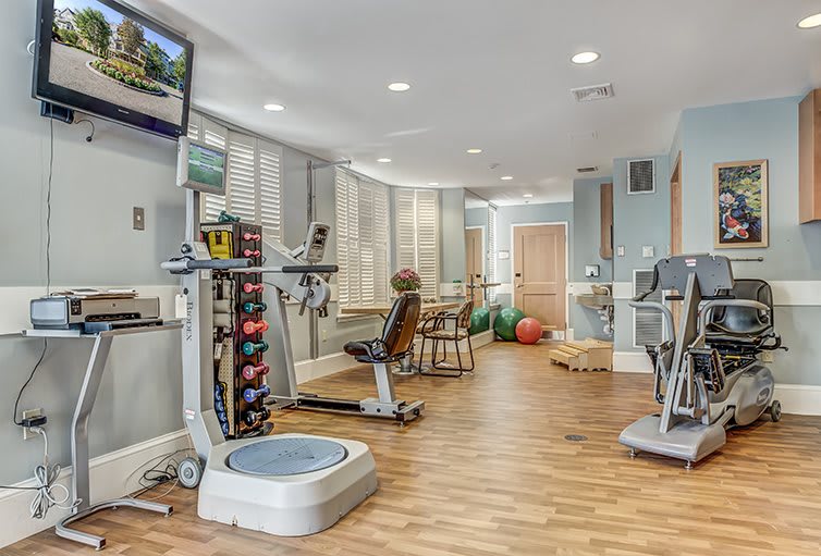 A modern gym interior featuring various exercise equipment.