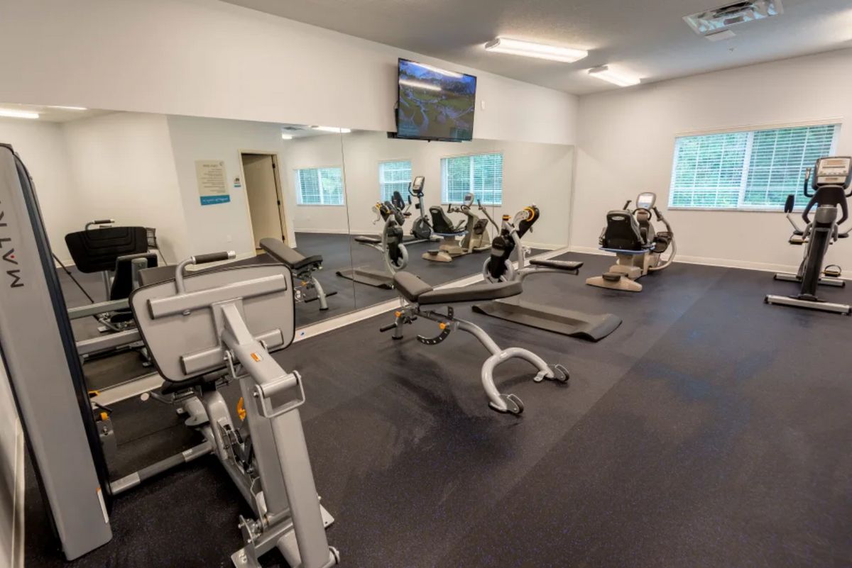 A well-equipped gym with various exercise machines and weights.