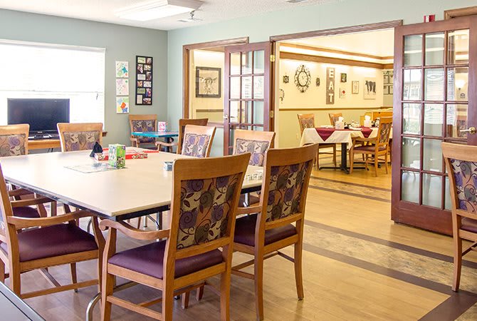 A cozy dining area with neatly arranged tables and chairs, adorned with warm decor.