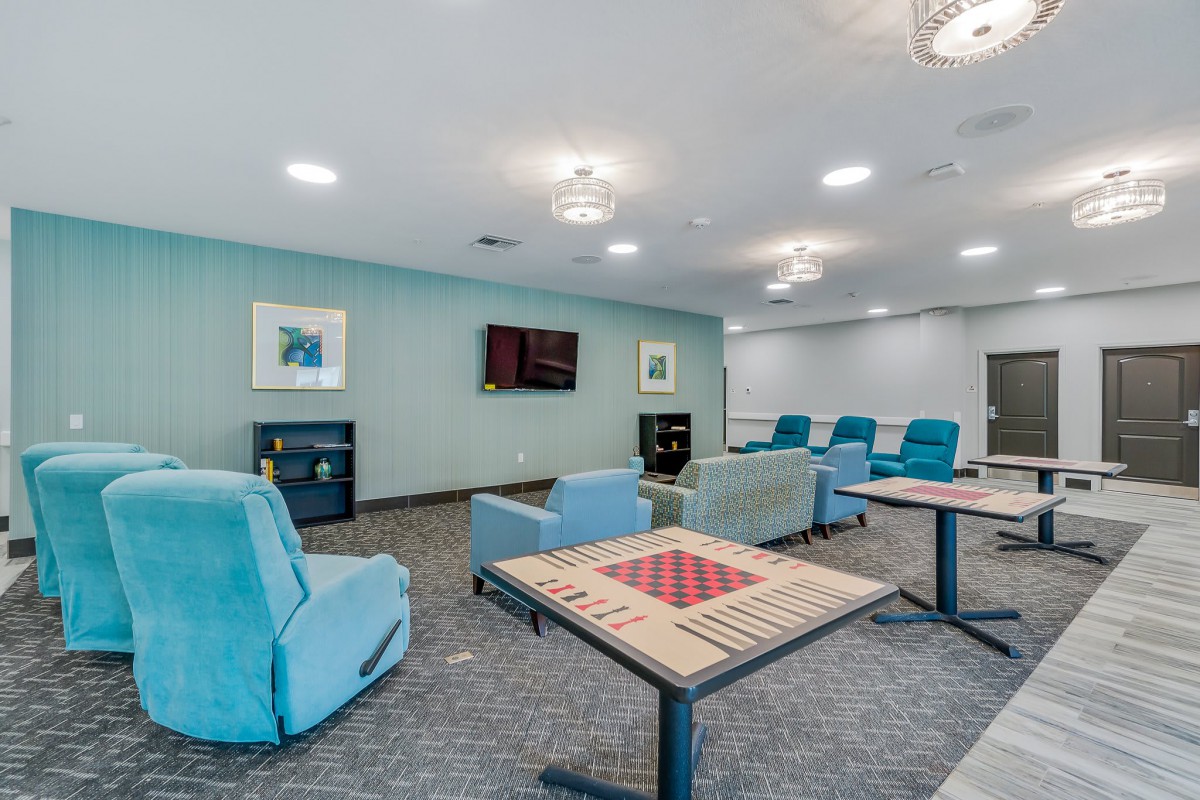 A modern lounge area with comfortable chairs and game tables.