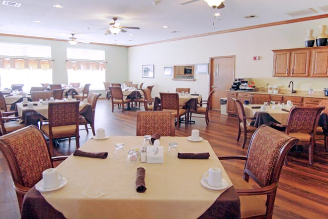 An empty dining room with neatly set tables and chairs.