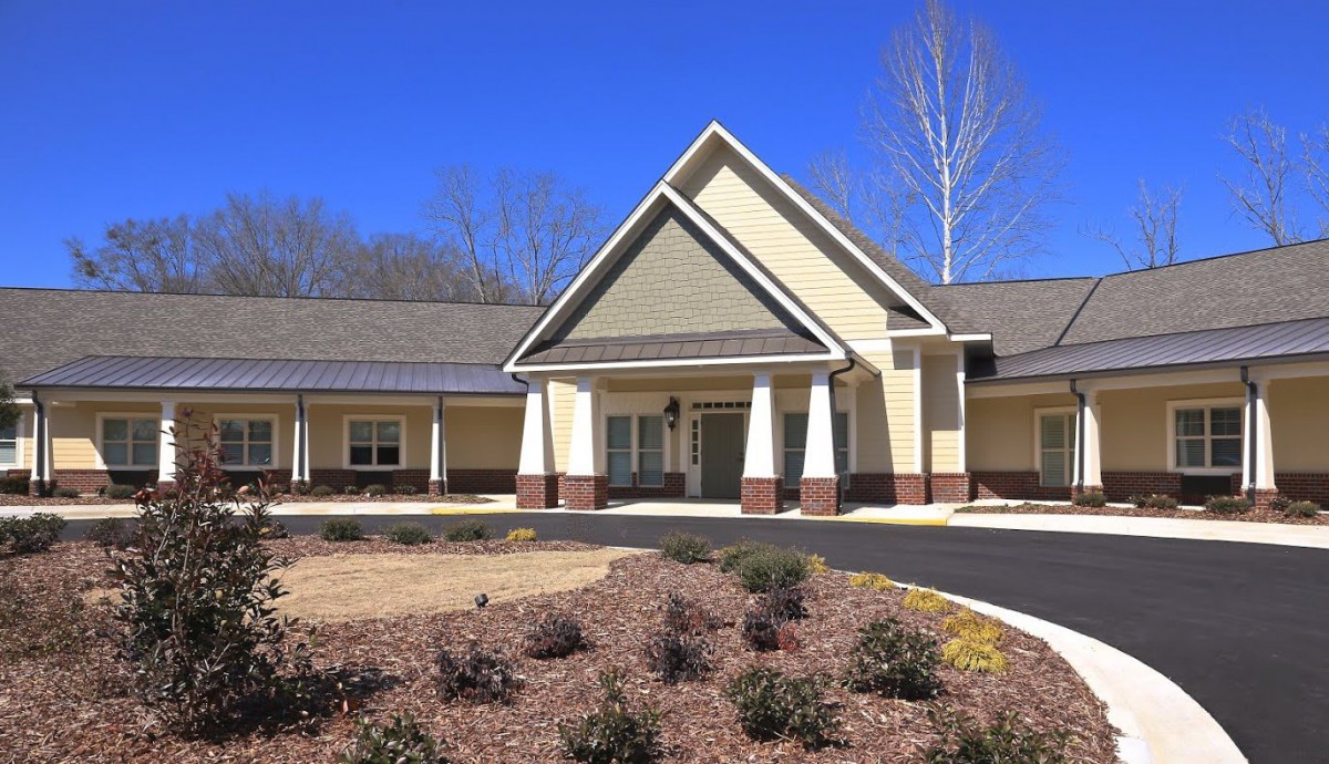 A modern residential facility with a symmetrical design and landscaped surroundings.