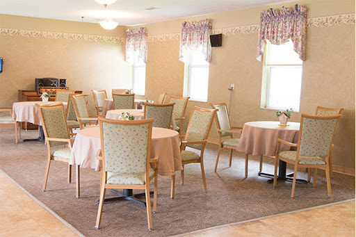 A spacious dining area set up for an event with soft lighting and elegant decor.