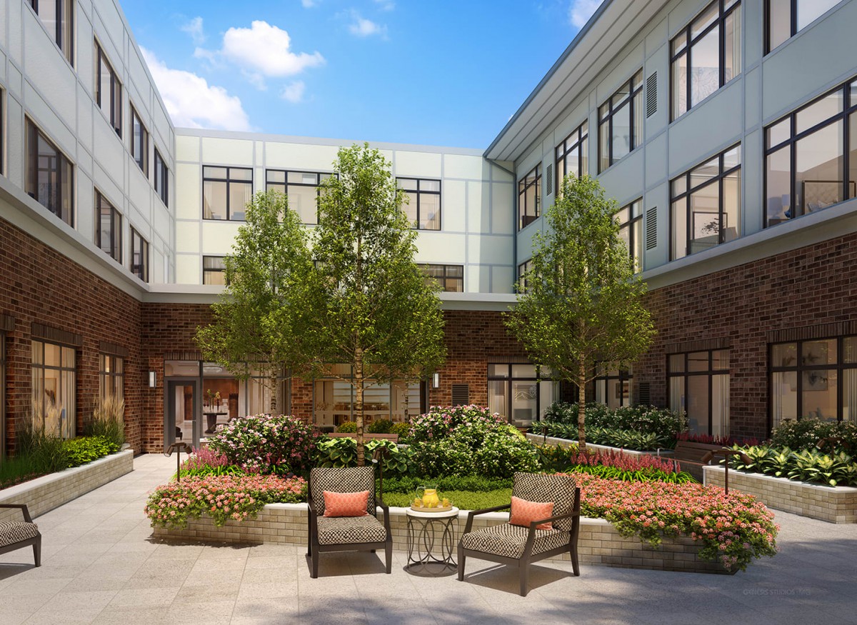 A peaceful courtyard with lush greenery and comfortable seating surrounded by a modern building.