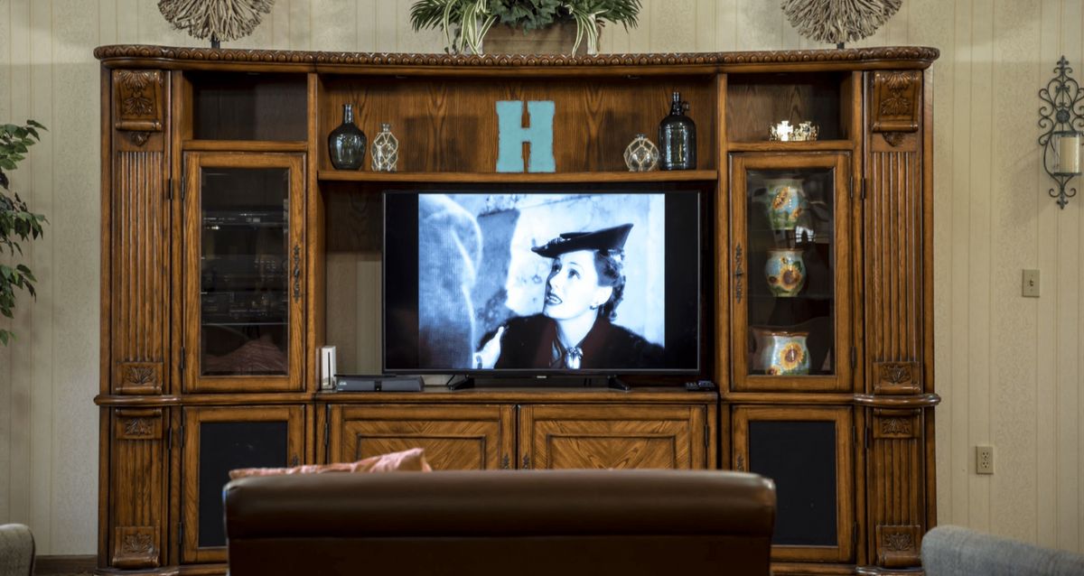 A vintage movie plays on a television in a cozy living room setting.