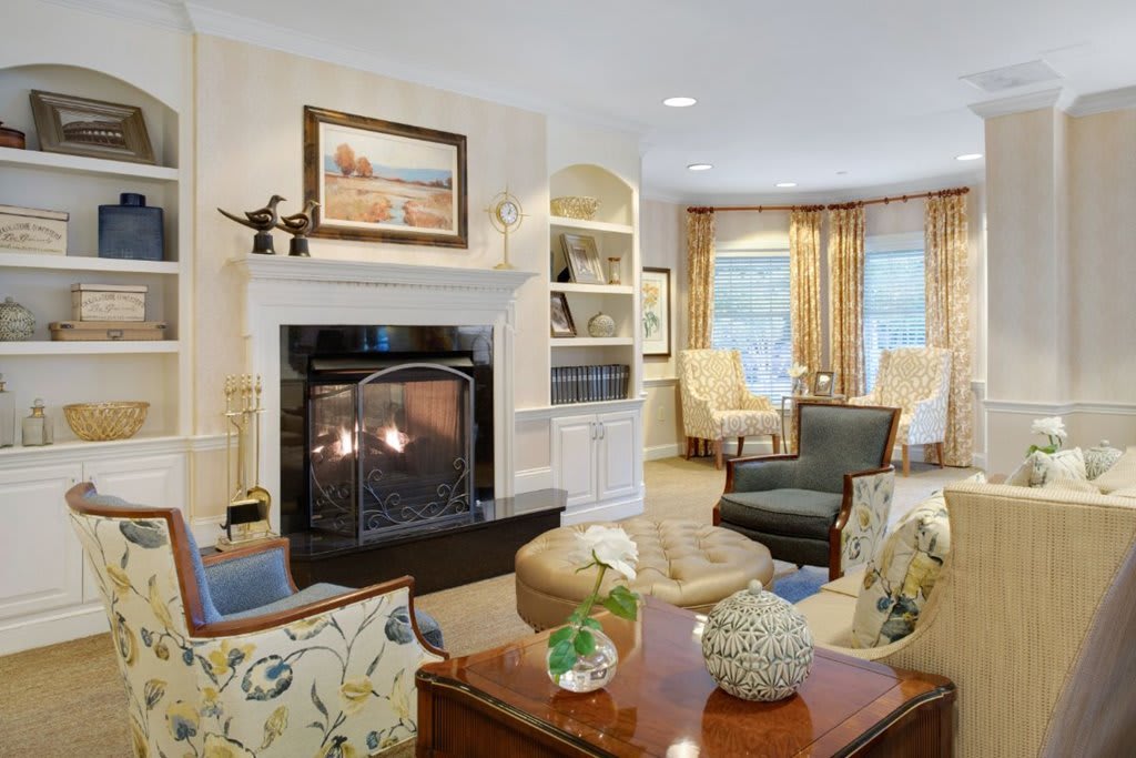 A cozy living room with a fireplace, comfortable seating, and elegant decor.
