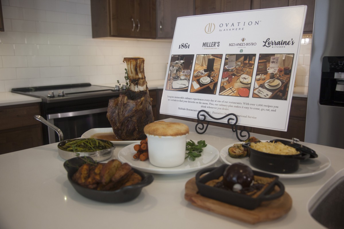 A gourmet meal setup featuring various dishes alongside a menu display on a restaurant table.