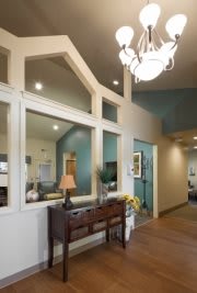 A modern entryway with a chandelier and elegant decor.