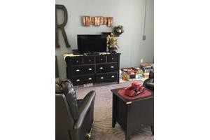A cozy living room setup with a television atop a dresser, surrounded by elegant decor.