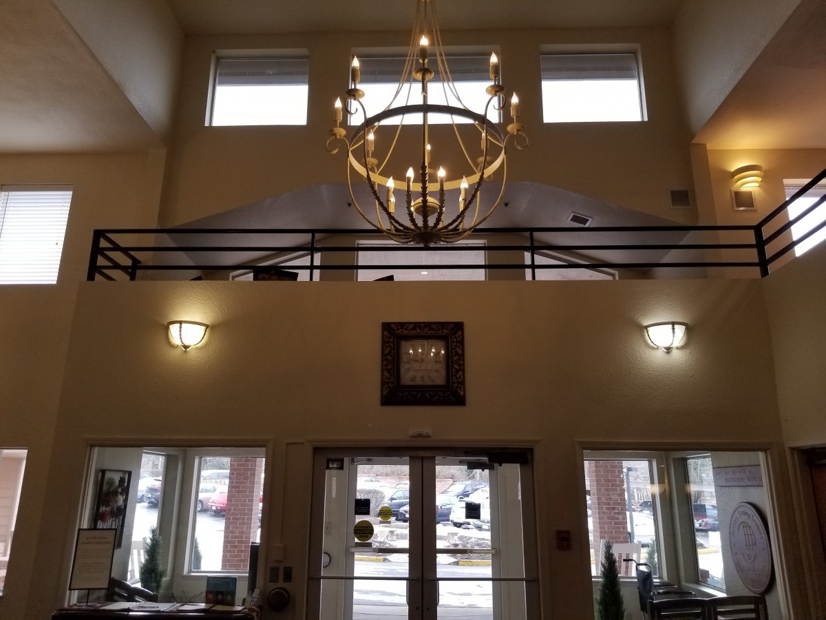 Interior view of a building lobby with chandelier and balcony.
