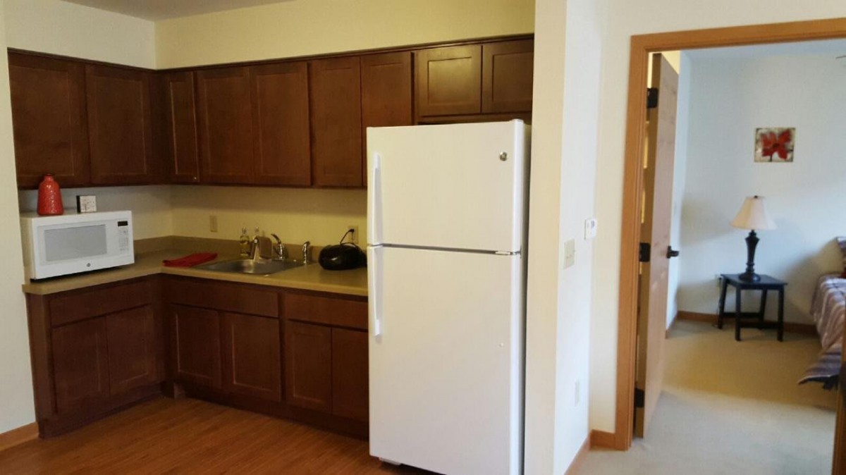 A kitchen interior featuring wooden cabinets and a white refrigerator.