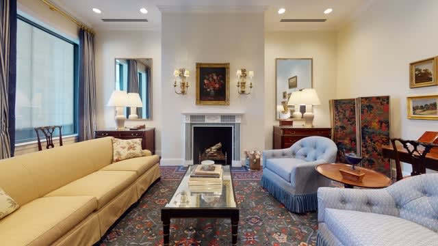 A well-decorated living room featuring a fireplace, sofas, an armchair, and a coffee table.