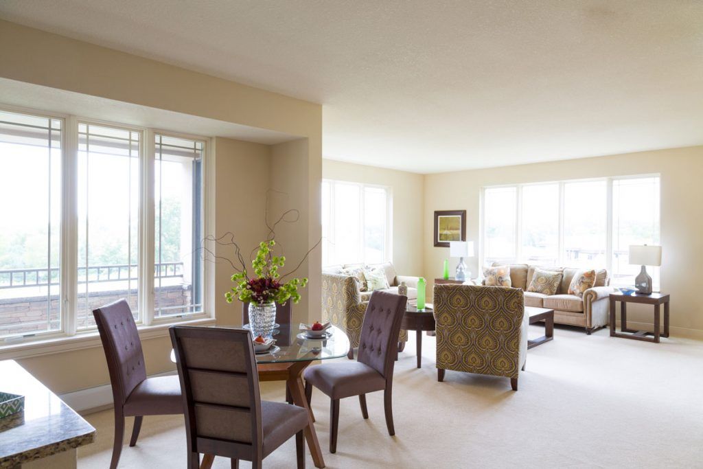 A spacious living and dining area with elegant furniture and large windows.