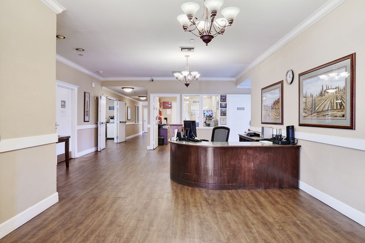 A well-lit office reception area with a front desk and chandelier.