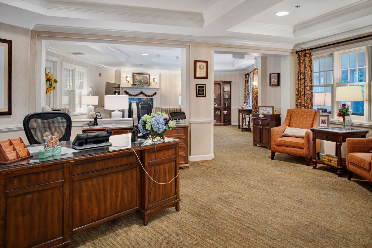A spacious and elegantly decorated office reception area with wooden furniture and comfortable seating.
