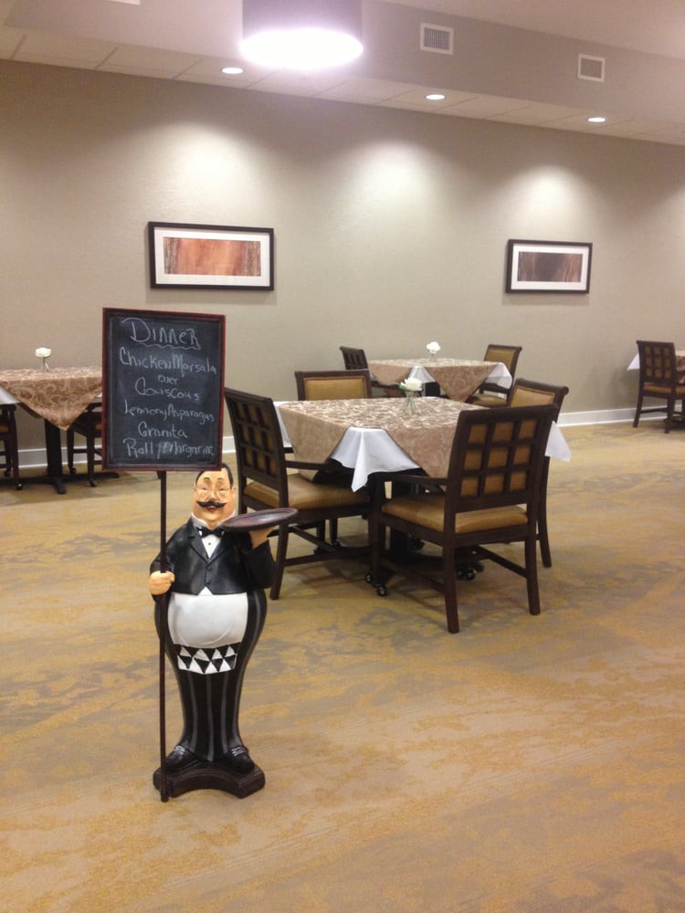 An empty restaurant dining area with neatly set tables and a menu sign at the entrance.