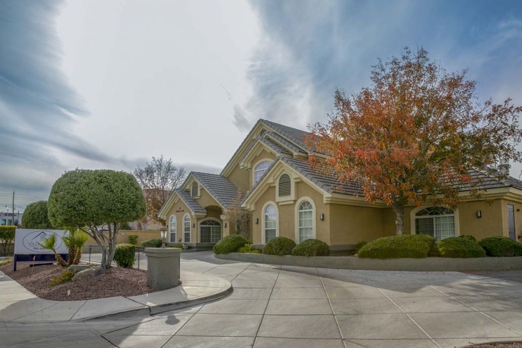 A residential house with autumn trees and a driveway.